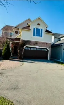 a large house with a garage and a driveway at Sunnys Home Stays TorontoMississauga Pvt Entrance 2B'Rm Bath Living & Kitchen in Mississauga