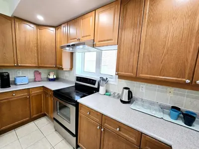 a kitchen with wooden cabinets and a stove top oven at Harbour for rest in Vaughan