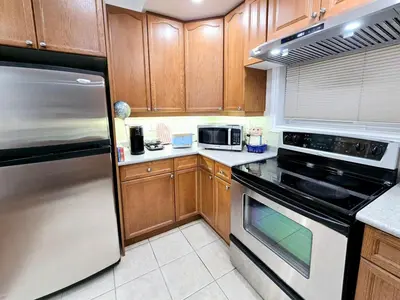 a kitchen with wooden cabinets and stainless steel appliances at Harbour for rest in Vaughan