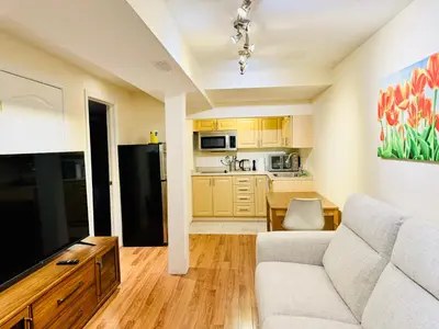 a living room with a couch and a kitchen at Modern 1-Bedroom Apartment - Near Airport & Toronto Downtown in Brampton