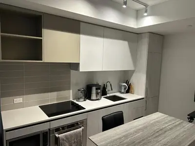 a kitchen with white cabinets and a table in it at The Evergreen Shelter in Vaughan