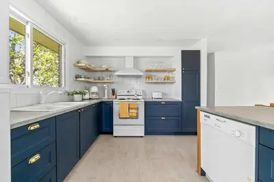 a kitchen with blue cabinets and a white stove at Field of Dreams in Bloomfield
