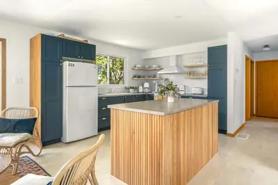 a kitchen with blue cabinets and a white refrigerator at Field of Dreams in Bloomfield