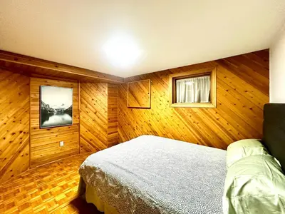 a bedroom with a bed in a room with wooden walls at Cozy and spacious vacation home in Toronto in Toronto