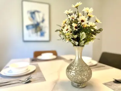 a vase filled with white flowers on a table at Cozy and spacious vacation home in Toronto in Toronto