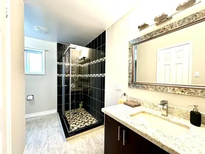 a bathroom with a shower and a sink and a mirror at Cozy and spacious vacation home in Toronto in Toronto