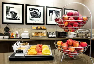 a buffet with a basket of apples and other food at Hampton Inn & Suites by Hilton Bolton in Bolton