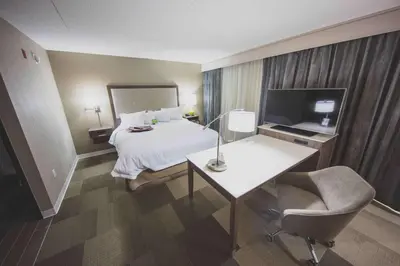 a hotel room with a bed and a desk and a television at Hampton Inn & Suites by Hilton Bolton in Bolton