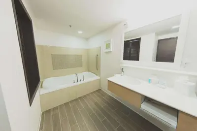 a white bathroom with a tub and a sink at Hampton Inn & Suites by Hilton Bolton in Bolton