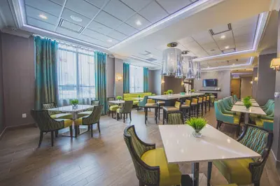 a dining room with tables and chairs in a restaurant at Hampton Inn & Suites by Hilton Bolton in Bolton