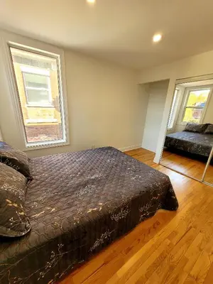 a bedroom with a bed and two windows at Deluxe Queen Rooms Downtown in Toronto