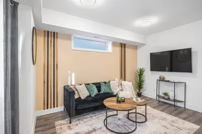 a living room with a couch and a table at Cozy 2BR Family Friendly Retreat With Parking and Just 6 Minutes away from Niagara Falls in Niagara Falls