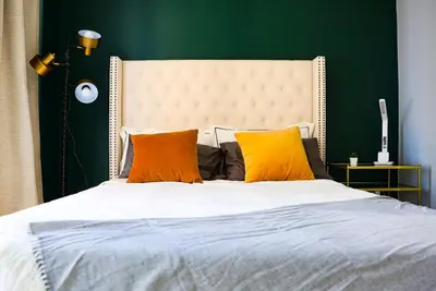 a bedroom with a large white bed with orange pillows at Stunning suite in downtown perfect for businesses trips and small families in Toronto