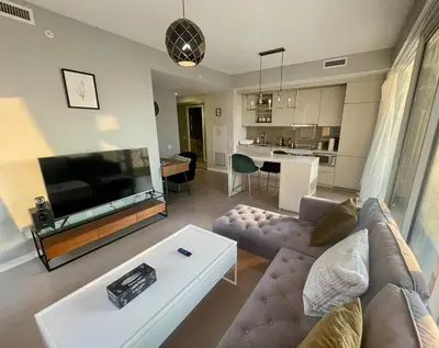 a living room with a couch and a large television at Stunning suite in downtown perfect for businesses trips and small families in Toronto