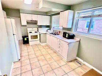a kitchen with white appliances and a tile floor at Private Room Near Airport D9 in Brampton