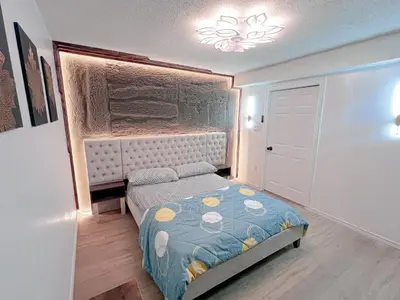 a small bedroom with a bed and a chandelier at Private Room Near Airport D10 in Brampton