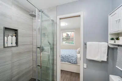 a bathroom with a shower with a glass door at Resort-like 4BR 3BA near Downtown, Four seasons Hot Tub, Gym, King Bed in Toronto
