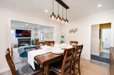 a dining room and living room with a table and chairs at Resort-like 4BR 3BA near Downtown, Four seasons Hot Tub, Gym, King Bed in Toronto