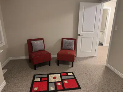 two red chairs and a rug in a room at A Compact family home in Milton in Milton