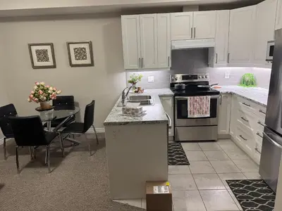 a kitchen with a stove and a table with chairs at A Compact family home in Milton in Milton