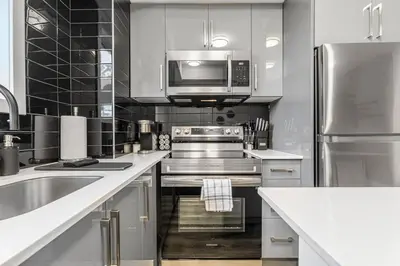a kitchen with stainless steel appliances and a microwave at NEW Stylish 1BR Apartment With BBQ and Situated Close to the Falls and Can Sleep 4 Guests in Niagara Falls
