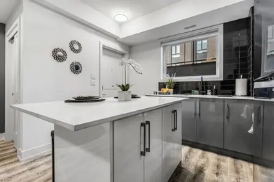 a kitchen with a large white counter and a window at NEW Stylish 1BR Apartment With BBQ and Situated Close to the Falls and Can Sleep 4 Guests in Niagara Falls