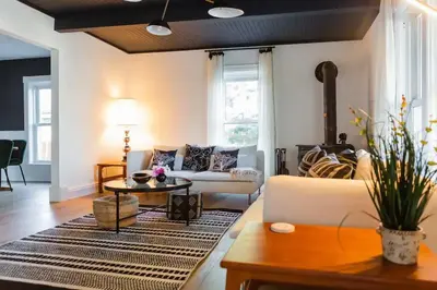 a living room with a couch and a table at The Vue - Nestled by Roblin's Lake with a Hot Tub in Mountain View
