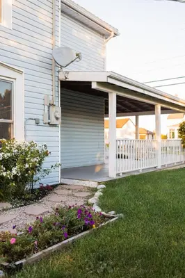 a house with an open garage with flowers in the yard at The Vue - Nestled by Roblin's Lake with a Hot Tub in Mountain View