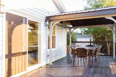 a patio with a table and chairs on a deck at The Vue - Nestled by Roblin's Lake with a Hot Tub in Mountain View
