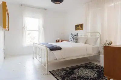 a white bedroom with a white bed and a window at The Vue - Nestled by Roblin's Lake with a Hot Tub in Mountain View