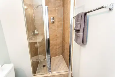 a shower with a glass door in a bathroom at Executive 2BR 2BATH Condo with Lakeview Steps from SQ1 in Mississauga
