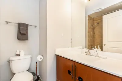 a bathroom with a toilet and a sink and a mirror at Executive 2BR 2BATH Condo with Lakeview Steps from SQ1 in Mississauga
