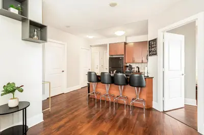 an open kitchen with black stools in the middle at Executive 2BR 2BATH Condo with Lakeview Steps from SQ1 in Mississauga