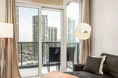 a living room with a large window with a view of the city at Executive 2BR 2BATH Condo with Lakeview Steps from SQ1 in Mississauga