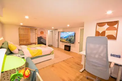 a bedroom with a bed and a tv in it at Family-Friendly 2BR Ground-Level Suite with Full Kitchen, Parking and 20 Minutes to Downtown in Toronto