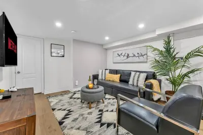 a living room with a couch and a tv at Family-Friendly 2BR Ground-Level Suite with Full Kitchen, Parking and 20 Minutes to Downtown in Toronto