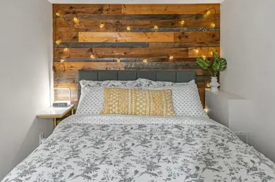 a bedroom with a bed with a wooden wall at Family-Friendly 2BR Ground-Level Suite with Full Kitchen, Parking and 20 Minutes to Downtown in Toronto