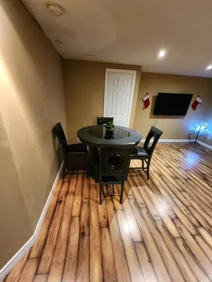 a dining room with a table and chairs and a flat screen tv at The Cozy Den in Ingersoll