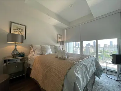 a bedroom with a bed and a large window at Toronto Bloor & Yonge Luxury Condo in Toronto
