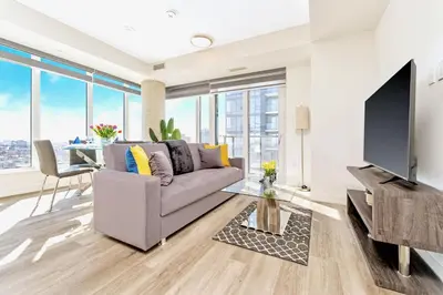 a living room with a couch and a tv at High Rise 1BR Building w Gorgeous Views in Kitchener