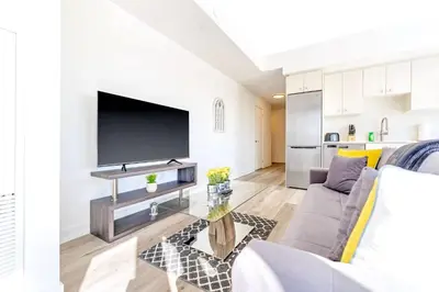 a living room with a couch and a tv at High Rise 1BR Building w Gorgeous Views in Kitchener