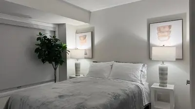 a bedroom with a bed with two lamps and a plant at Ivylea Elegant Luxury Estate Richmond Hill in Richmond Hill