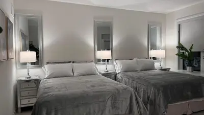 two beds in a room with two lamps and mirrors at Ivylea Elegant Luxury Estate Richmond Hill in Richmond Hill