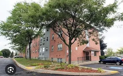 a large brick building with a tree in front of it at 56 Hiawatha in Woodstock