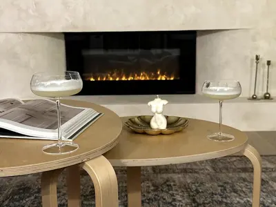 two wine glasses on a table in front of a fireplace at The White House in Caledonia