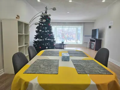 a large yellow table with a christmas tree in a room at A Home Away-Cozy Guest Room in Toronto in Toronto