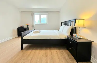 a bedroom with a large bed with a lamp on it at A Home Away-Cozy Guest Room in Toronto in Toronto