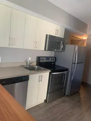 a kitchen with white cabinets and a stainless steel refrigerator at Sandy&Kevin#home in Waterloo