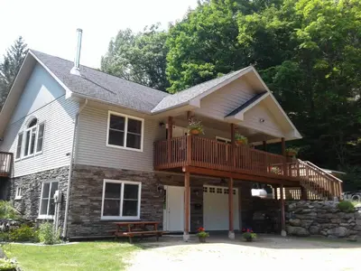 a house with a balcony and a deck at Stone Ridge Chalet Bed n Breakfast in Dorset