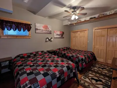a bedroom with two beds and a ceiling fan at Stone Ridge Chalet Bed n Breakfast in Dorset